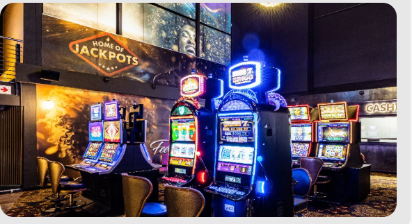 Casino gaming floor with illuminated gaming machines and gold-accented interiors